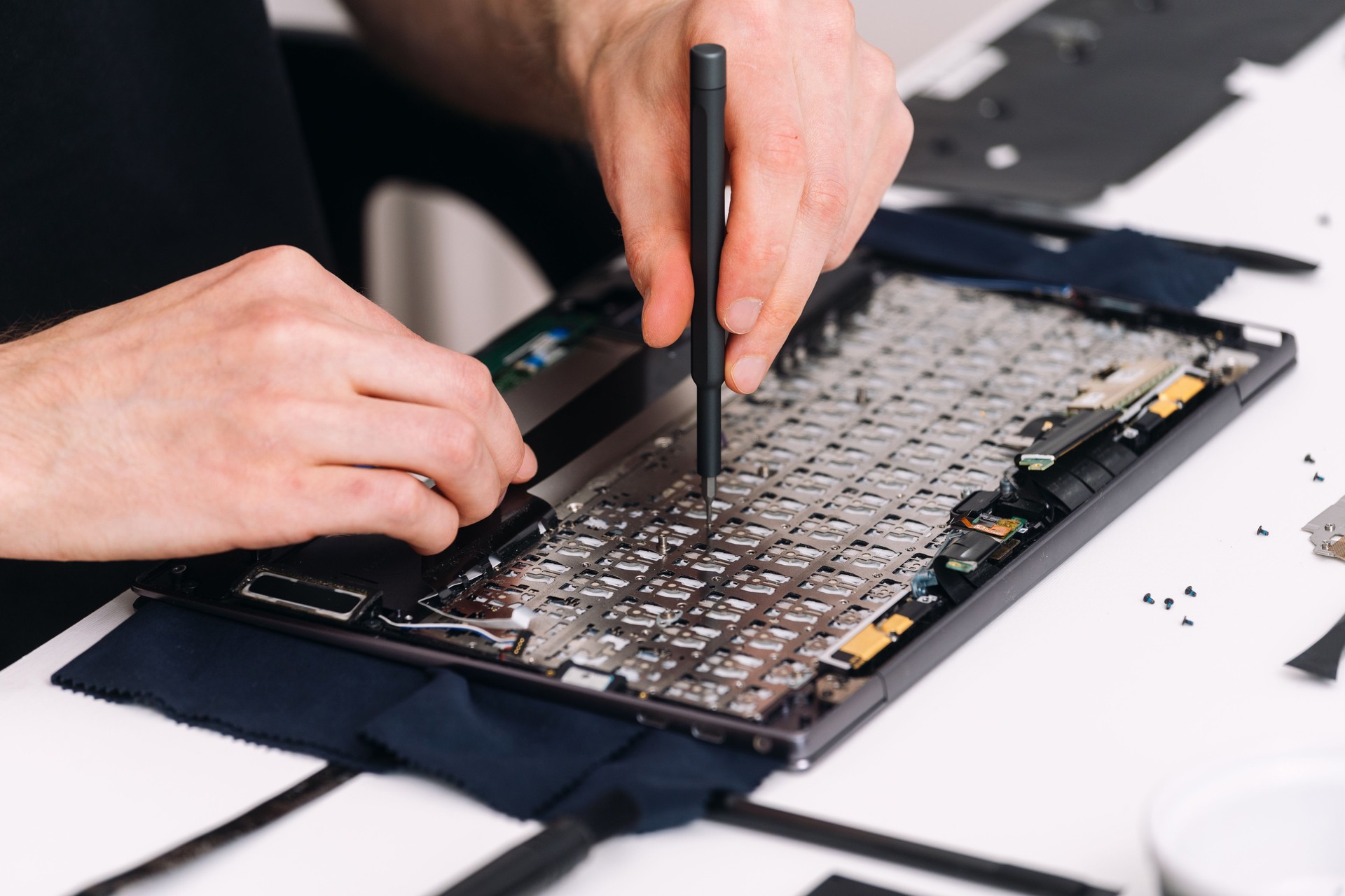 Man repairing broken laptop with tools in warranty service